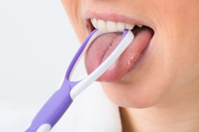 woman scraping tongue
